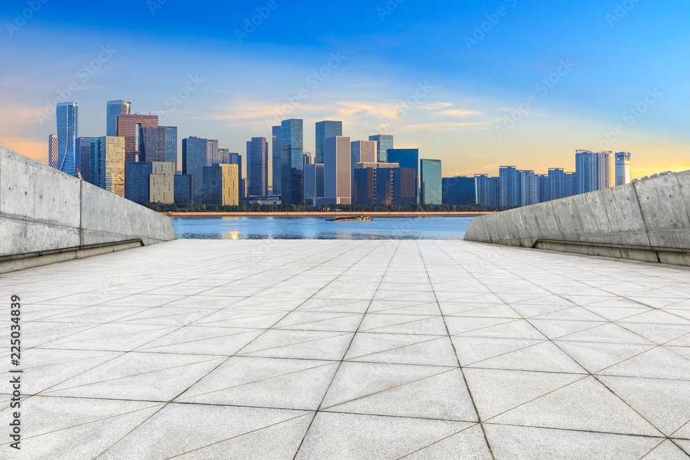 Empty square floor and modern city buildings with bridge in hangzhou at sunrise