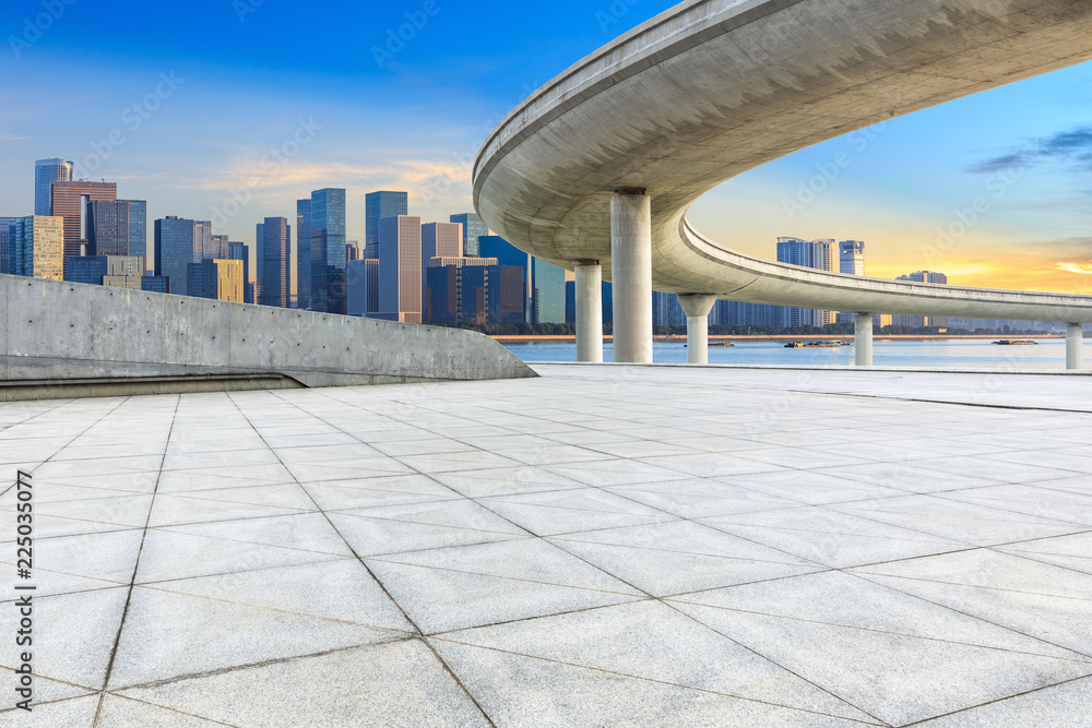 日出时杭州空荡荡的广场层和带桥的现代城市建筑