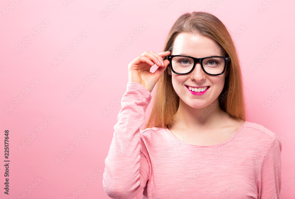 Young woman with eye glasses on a pink background