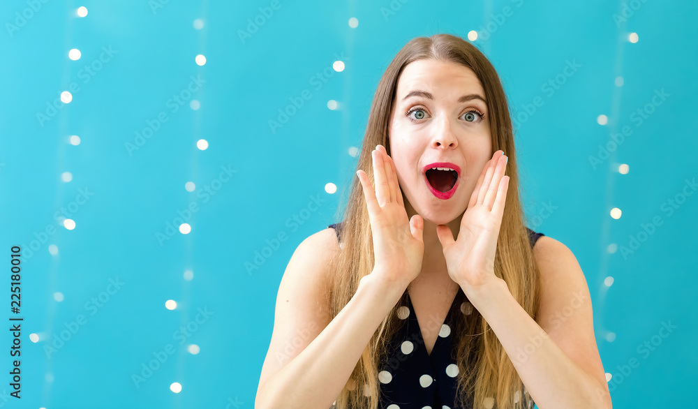 Young woman shouting on a shiny light background