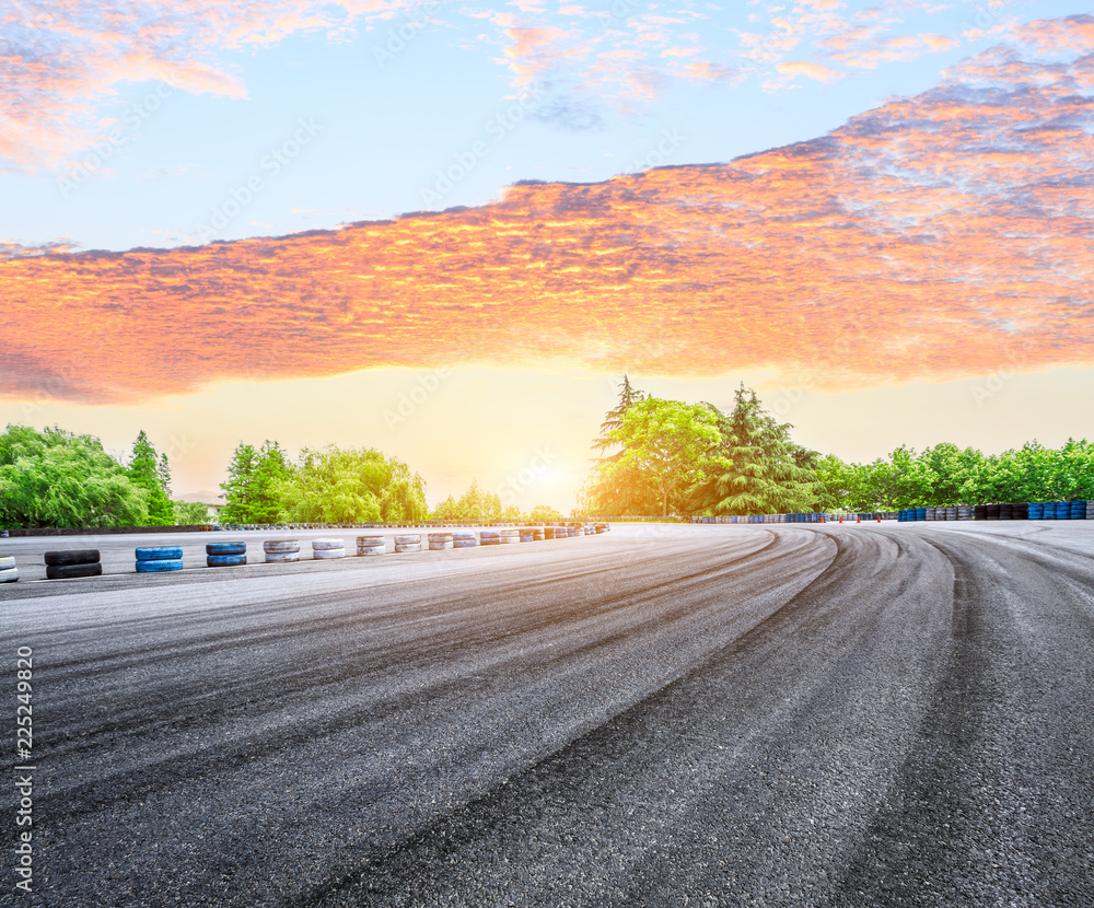 日落时分的沥青公路赛道和绿色森林自然景观