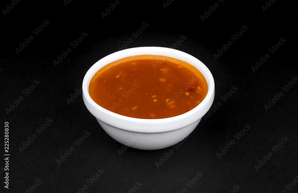 Sweet and sour sauce in bowl isolated on black background