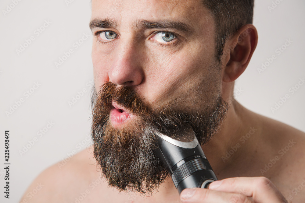 Bearded man shaving his face