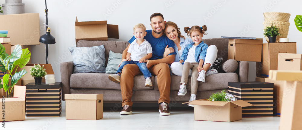 happy family mother father and children move to new apartment and unpack boxes