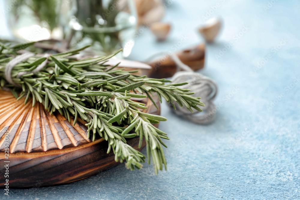 Wooden board with fresh rosemary on table, closeup