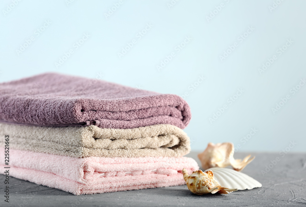 Clean folded towels on table against light background