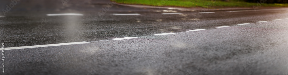 wet black asphalt road and white dividing lines