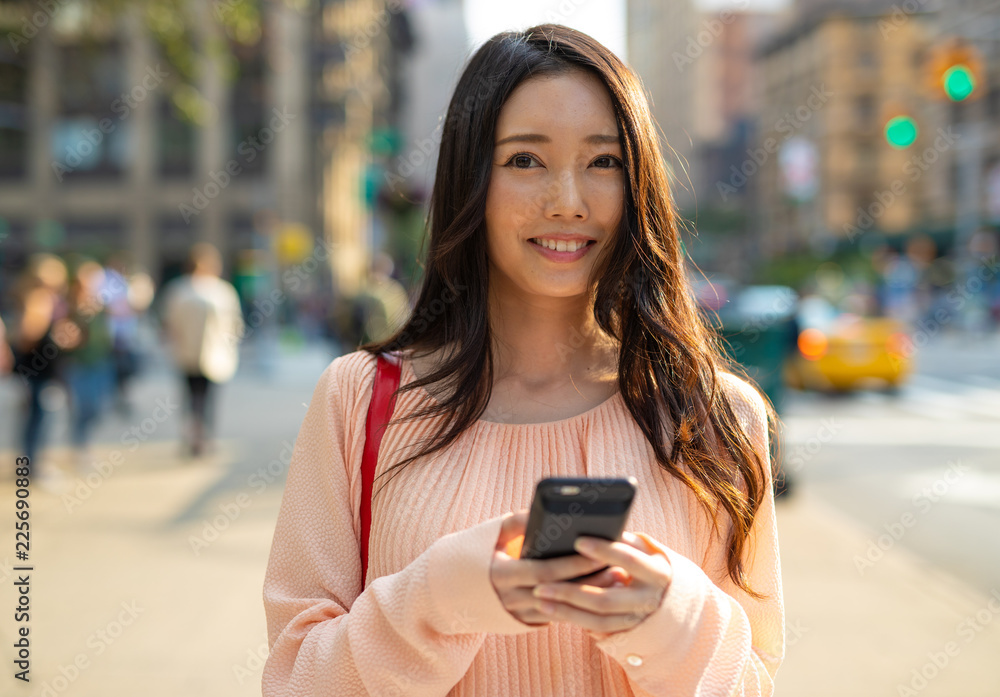 在城市里用手机走路的亚洲女性