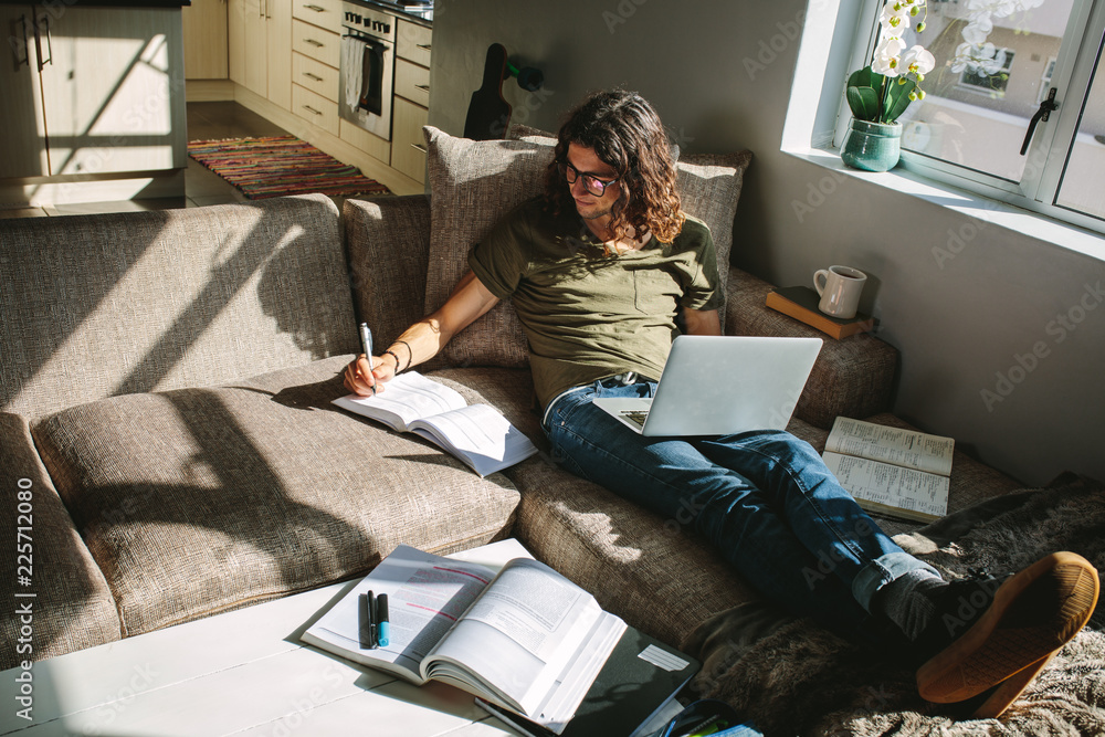 Student studying at home sitting beside a window