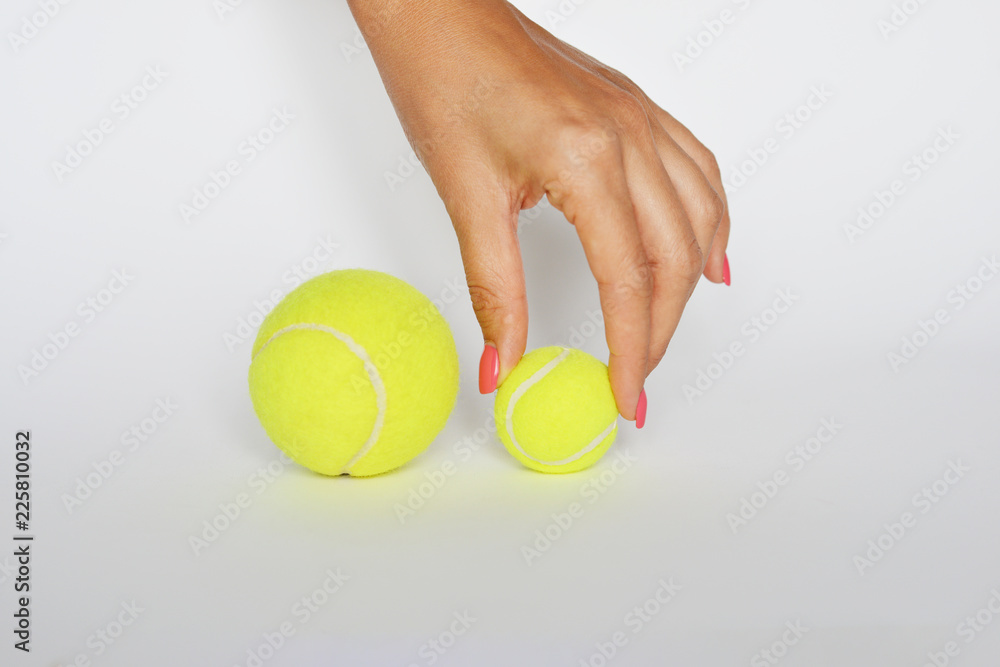 Hand of an debutant athlete choosing a small tennis ball on white background
