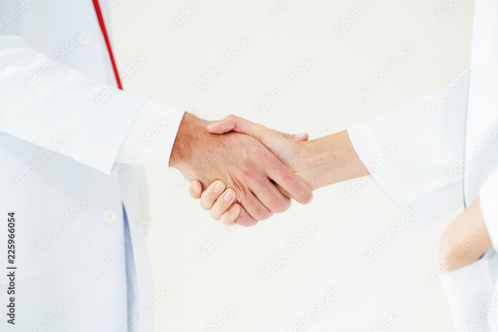 Doctor at hospital shakes hand with another doctor