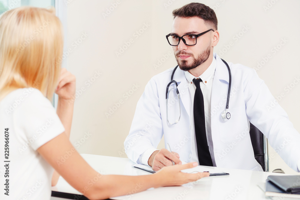 Male Doctor and Female Patient in Hospital Office