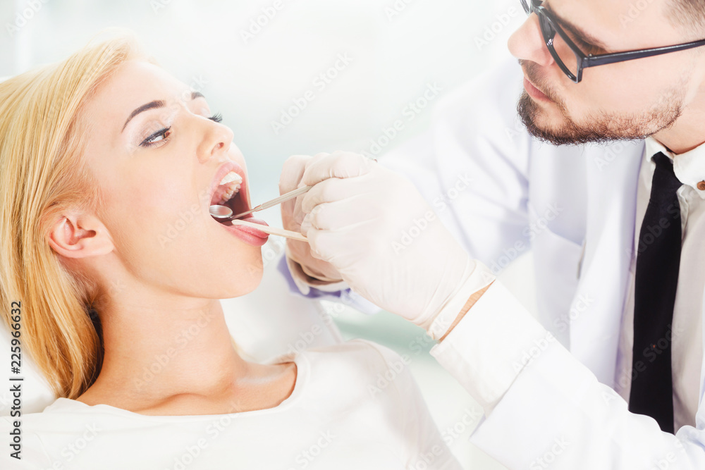 Young dentist examining patient in dental clinic.