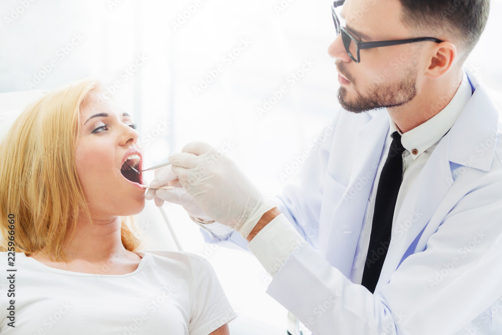 Young dentist examining patient in dental clinic.