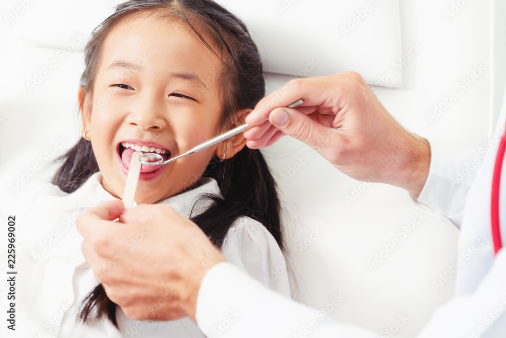 Dentist examining child teeth in dental clinic.