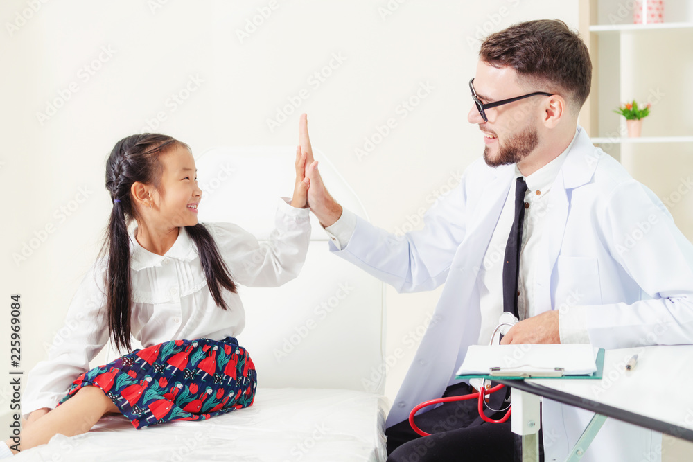 Doctor examining little happy kid in hospital.