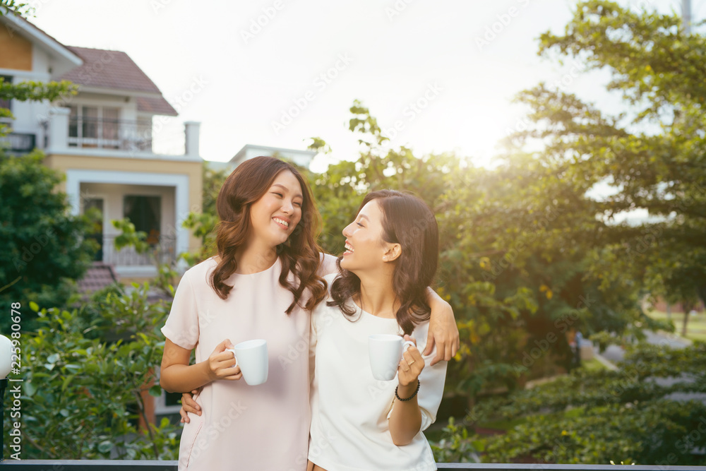 两个女人在屋顶花园喝咖啡放松