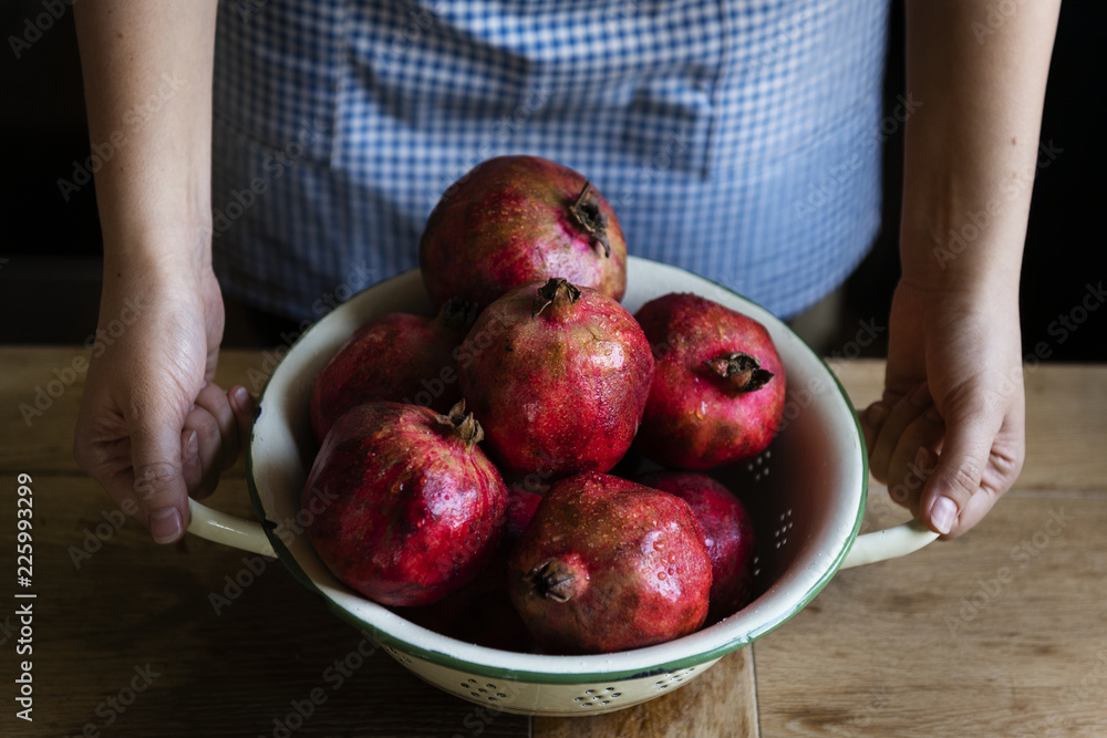 Fresh pomegranate in a bowl on a wooden table