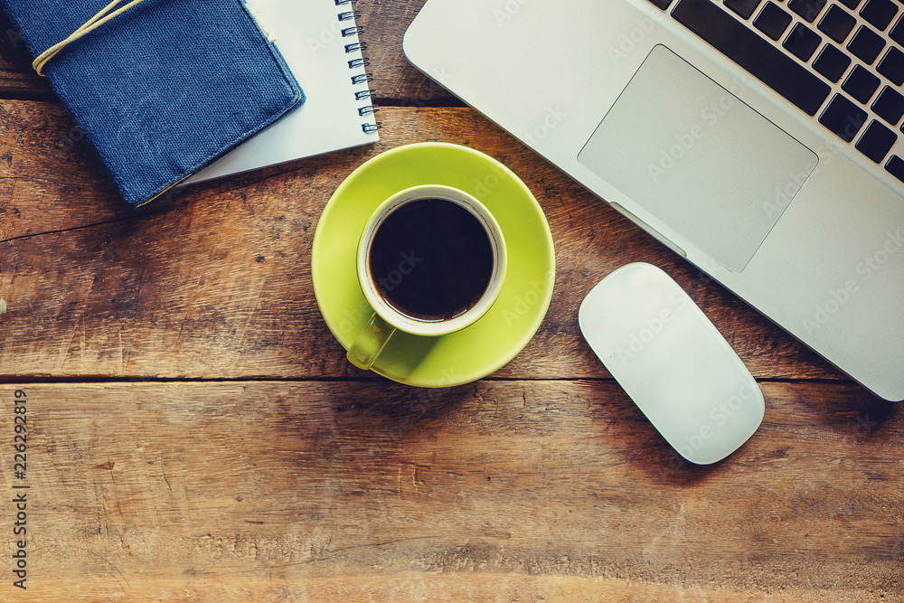 Wood office desk table with a lot of things tablet, laptop ,smartphone ,notepad and coffee cup notep