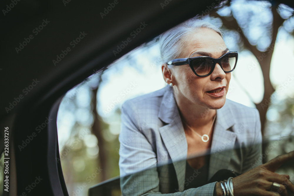 戴墨镜的女商人与出租车司机交谈