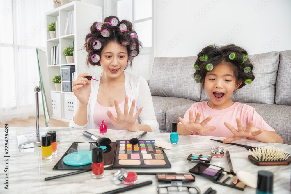 mom and little girl paiting nails themselves