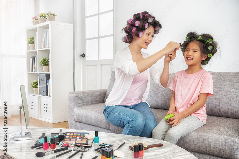 mom help to set daughters hair curly