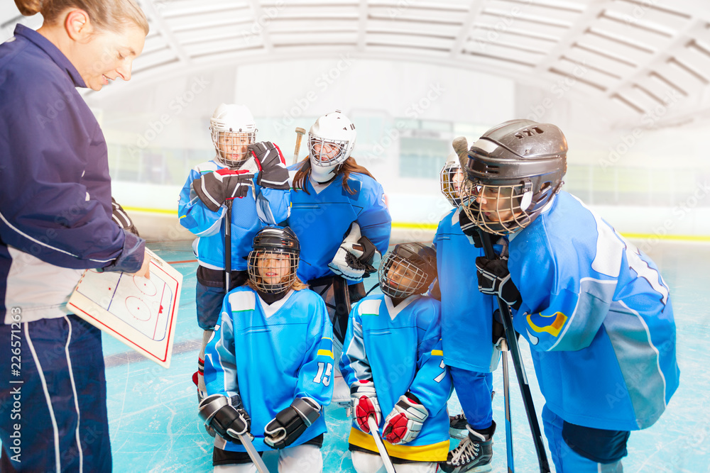 Female coach explaining strategy to hockey team