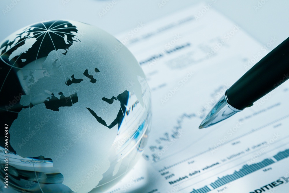 Glass Globe And Pen On Financial Report Close-up