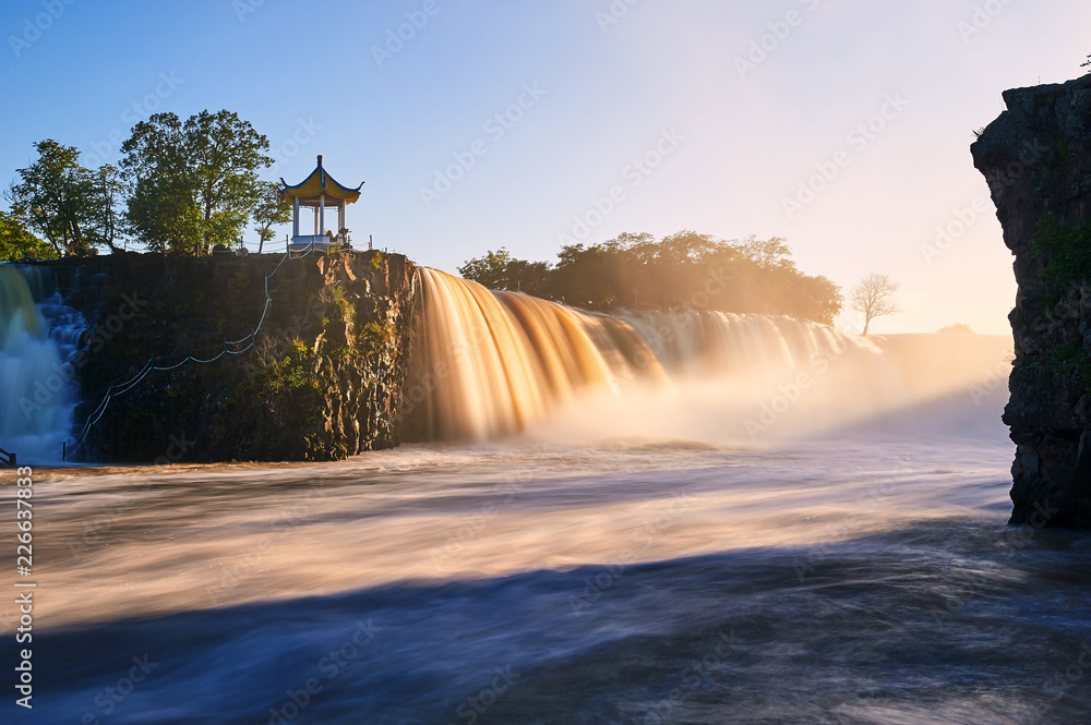 中国镜泊湖瀑布日落景观。