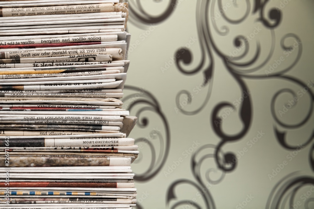 Pile of printed newspapers on blue background