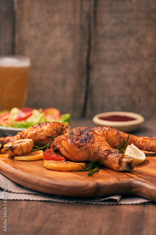 Chicken drumtick in on wood board