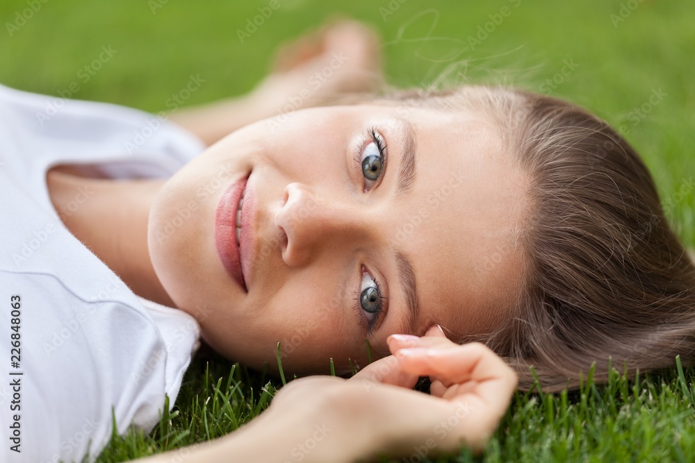 Portrait of a Young Woman Lying Down on the Grass