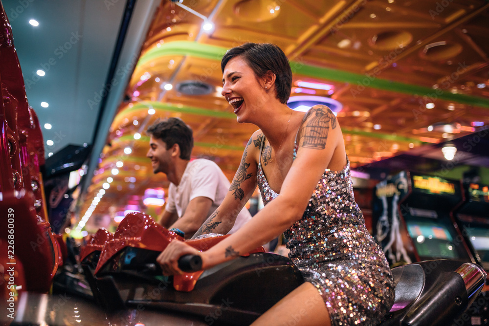 Happy couple having fun playing arcade racing games