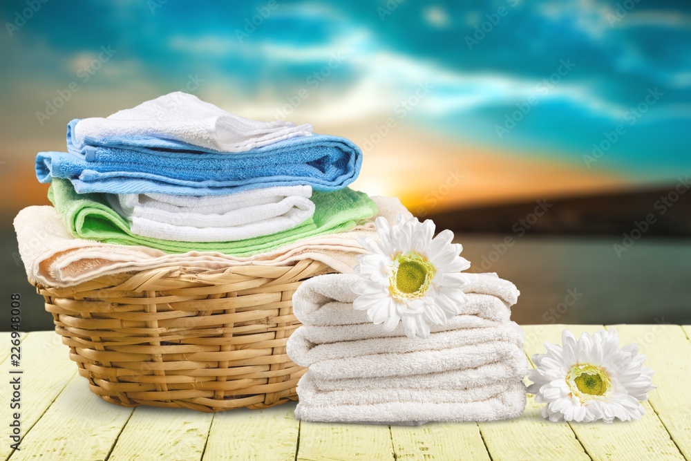 Laundry Basket with colorful towels on background