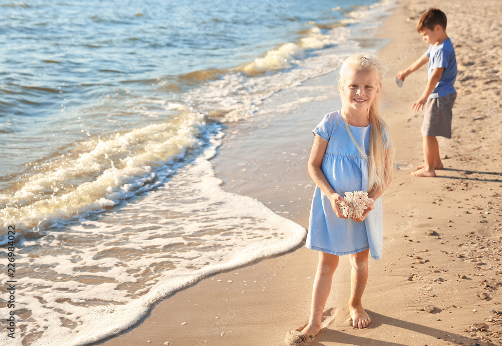 Cute little girl with coral on sea beach