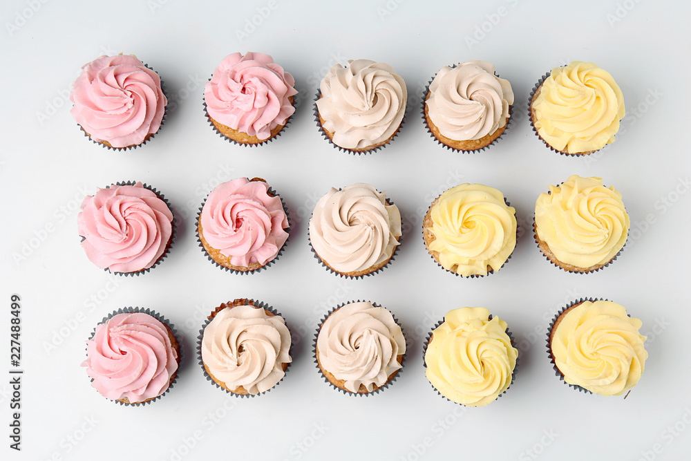 Delicious cupcakes on white background, flat lay