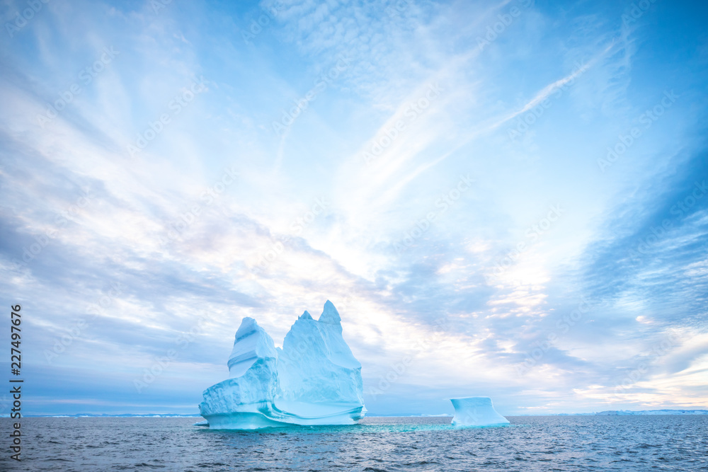 Photogenic and intricate iceberg under an interesting and colorful sky during sunset. Disko bay, Gre