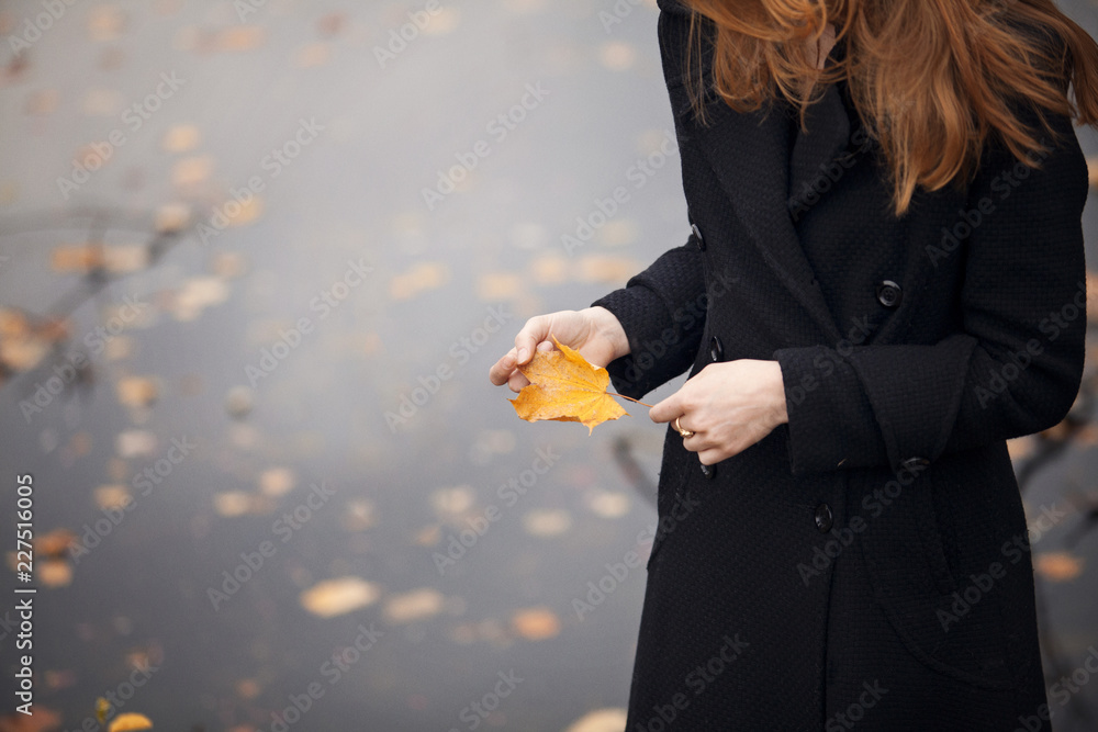 抱着秋黄叶的女人的中段