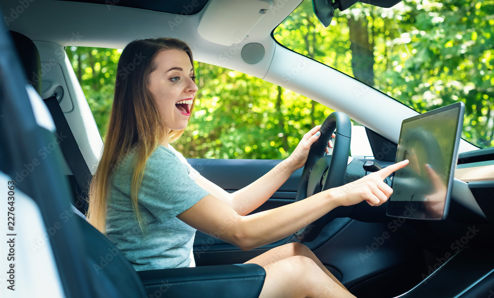 Happy young woman in a new luxury car