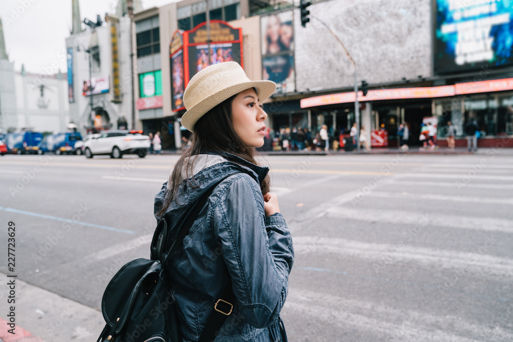 一名等待过马路的女性旅行者