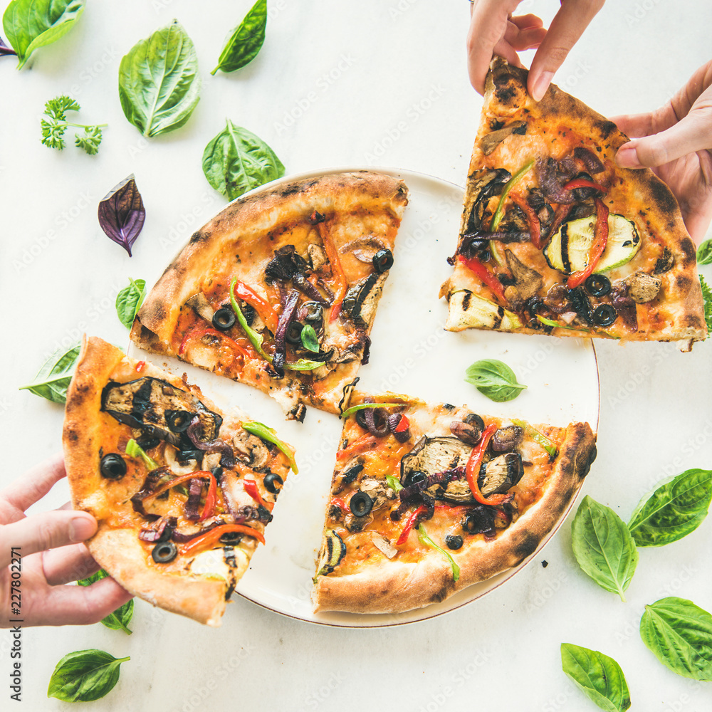 Summer dinner or lunch. Flat-lay of peoples hands taking freshly baked Italian vegetarian pizza wit