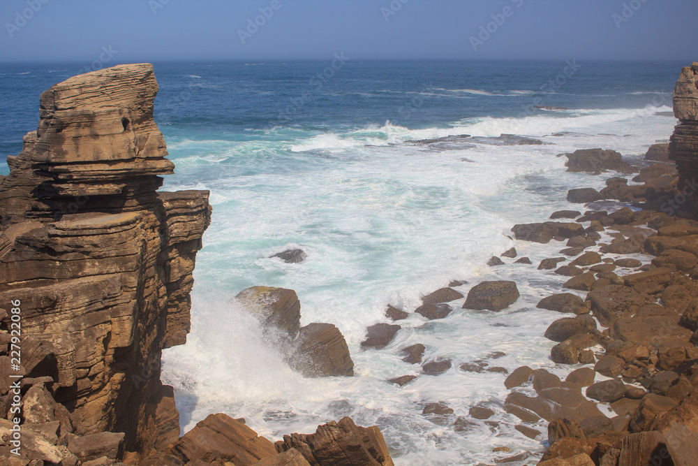 阳光明媚的日子里，海浪拍打着海岩海岸的全景。葡萄牙佩尼切海滨小镇。