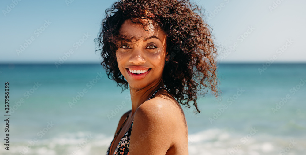 Portrait of a curly haired woman at the beach