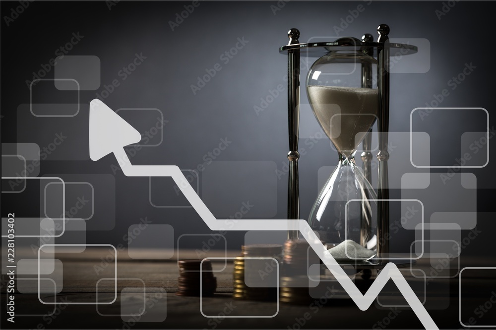 Sand running through the bulbs of an hourglass on business chart