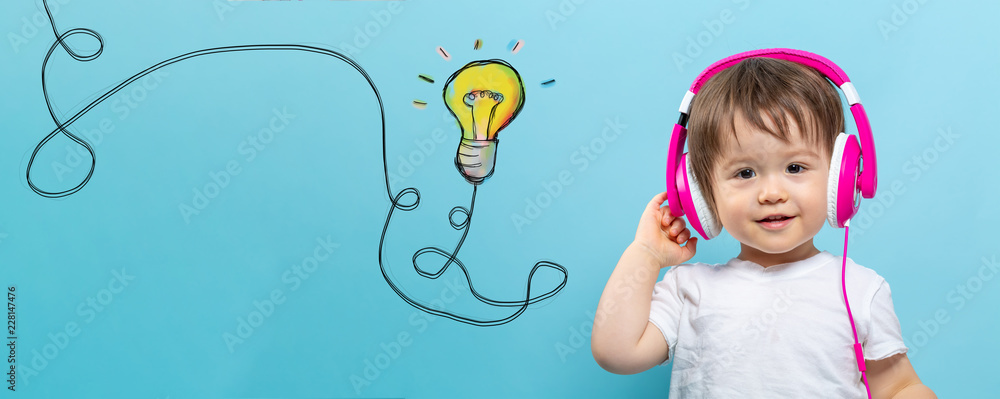 Light bulb with string with toddler boy with headphones on a blue background