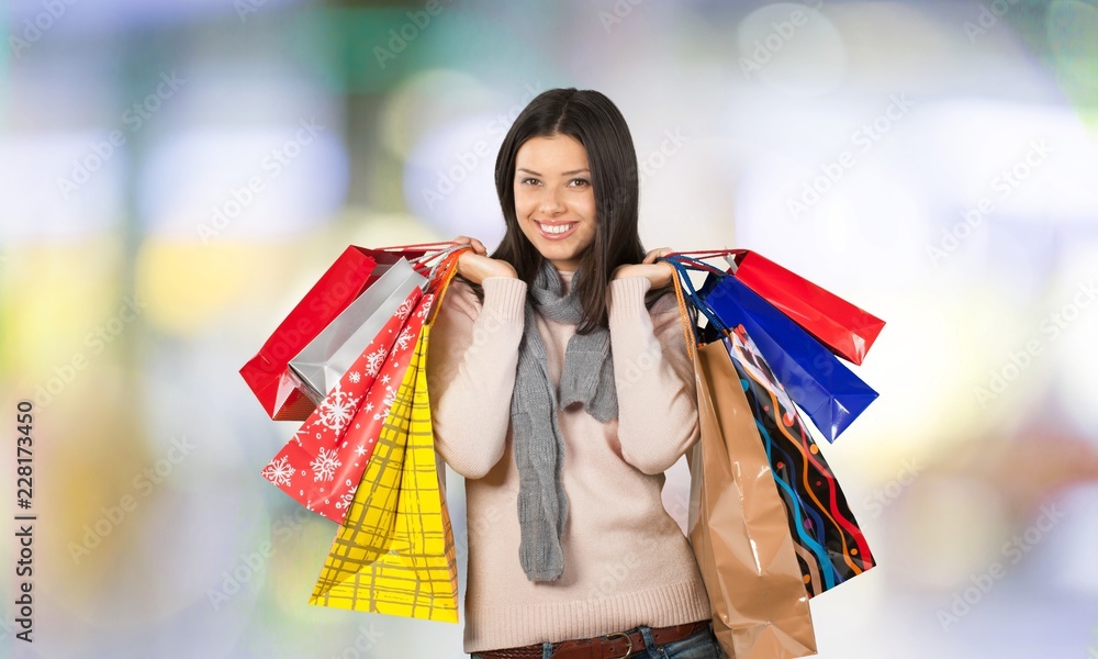 Young woman with shopping bags on  background