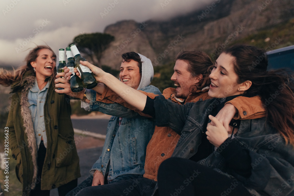 Two couples having fun partying sitting near a highway