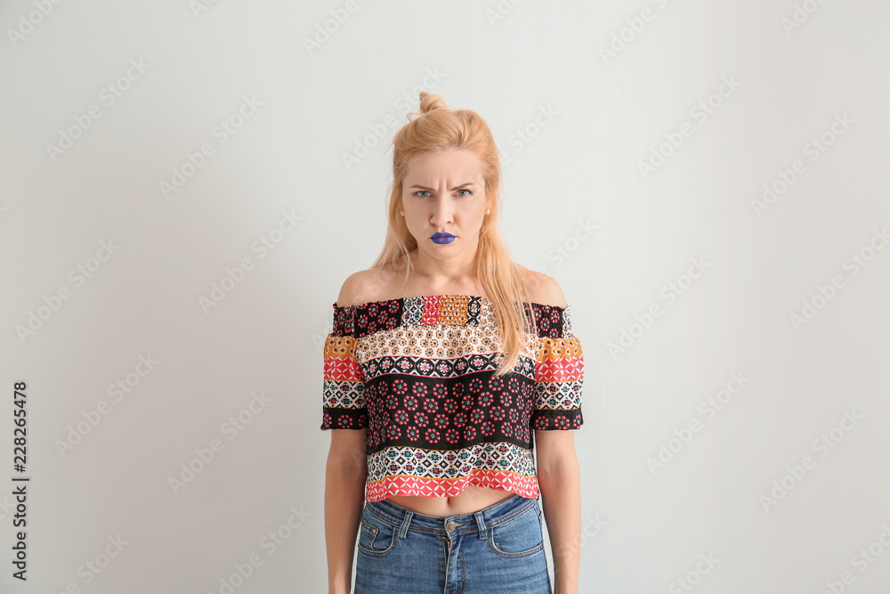 Portrait of beautiful displeased woman with unusual lipstick on white background