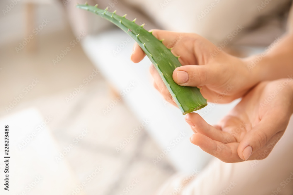 美丽的年轻女子在家使用芦荟，特写