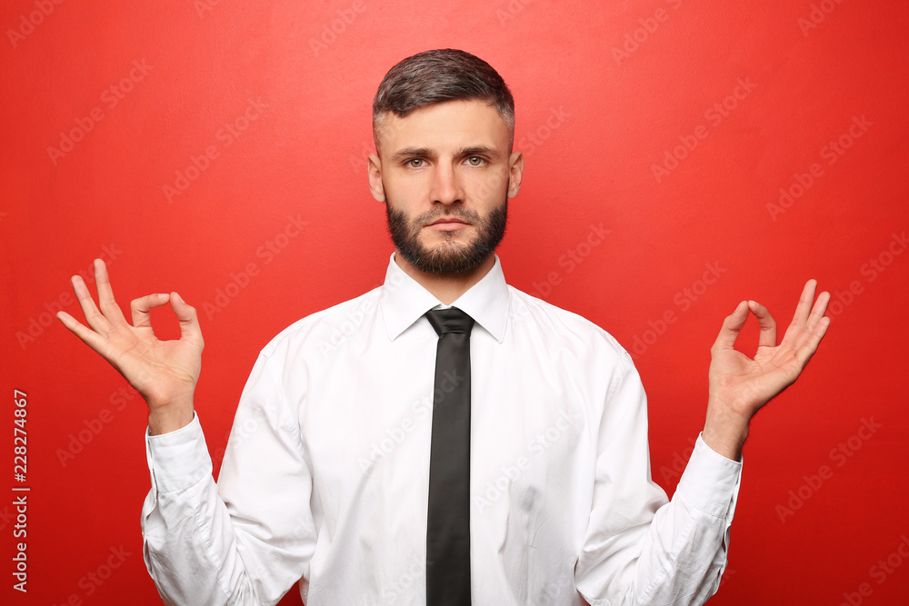 Handsome calm businessman on color background